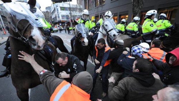 Mounted police and striking CFMEU workers clash outside the Grocon Myer construction site.