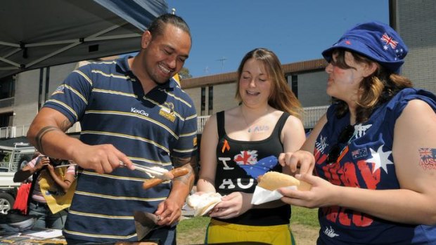 Manning the BBQ at University of Canberra Student Week is Fotu Auelua, serving students Sarah Skidmore, centre and Kim Lindsay.