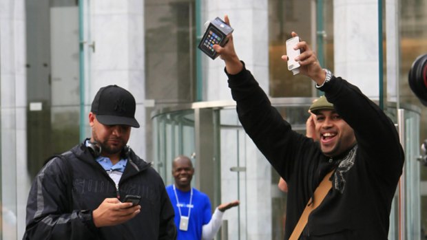 Osiris Caceres shows off an Apple iPhone 3G S he purchased at an Apple Store on Friday in New York.