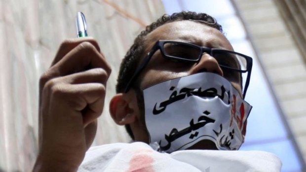 Dissent stifled: An Egyptian journalist protests against the country's Interior Ministry, which is accused of targeting journalists. The tape across his mouth reads "the blood of a journalist is not cheap".