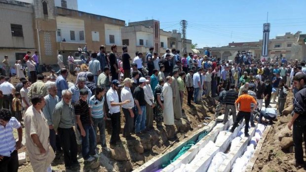 Mourners gather at a mass burial for victims of the artillery barrage in Houla.