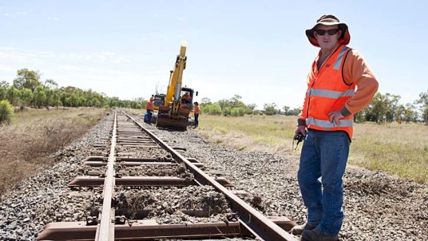 Rob Nicholls is one of the workers packing ballast under the line from Roma to Mitchell.