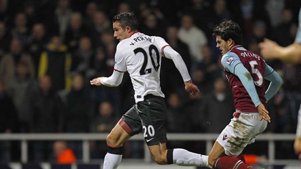 Manchester United's Robin van Persie makes tracks for goal as West Ham United's defender James Tomkins speeds in pursuit.