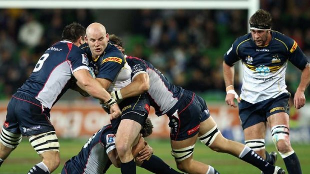 Halted, but elated .... Stephen Moore is seized upon by three Rebels players in his 50th cap for the Brumbies.