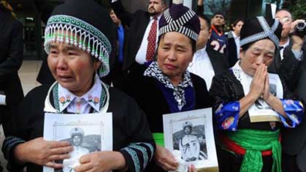 Hmong mourners watch General Vang Pao's funeral procession in Fresno.