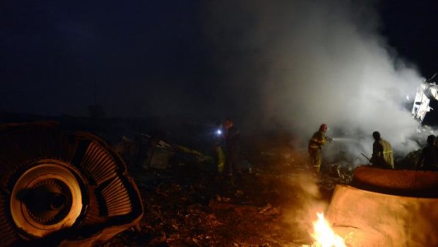 Firefighters extinguish blaze in the MH17 wreckage.
