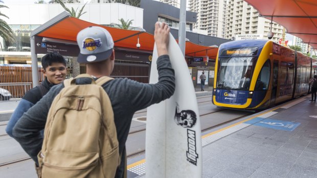 Surfers wait to board the Gold Coast light rail this week.