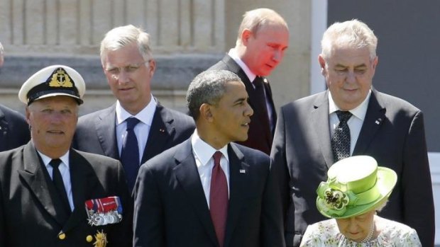 Russian President Vladimir Putin passes behind US President Barack Obama, Britain's Queen Elizabeth and Norway's King Harald as he arrives for the 70th anniversary of the D-Day landings at Benouville Castle.