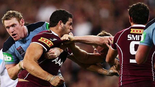 Fired up . . . Queensland centre Greg Inglis unleashes his fury on NSW counterpart Beau Scott at Suncorp Stadium last night.