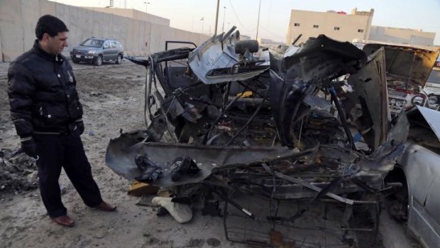An Iraqi man inspects vehicles damaged in a car bomb attack in Baghdad, Iraq.