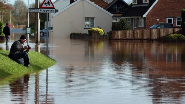 You won't believe this ... a man takes a photograph of flood water in the centre of the village of Ruishton, near Taunton.