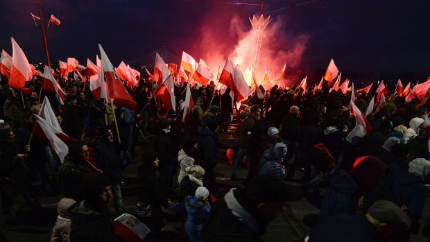 Demonstrators burn flares and wave Polish flags during the annual march to commemorate Poland's National Independence Day in Warsaw, Poland.