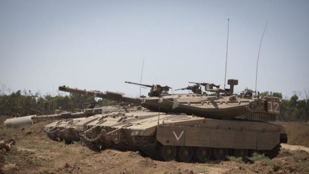 Israeli tanks sit at the border with Gaza.