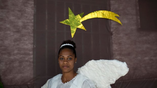 Dressed as a Christmas angel, a prisoner poses for a photo during a prison events that  includes a cell decorating contest and a skit dramatising biblical stories, in Rio de Janeiro, Brazil.