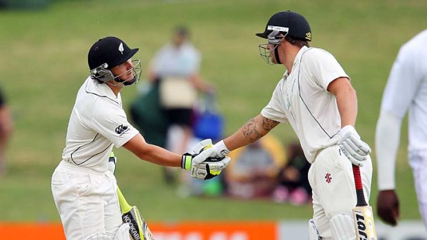 B.J. Watling of New Zealand is congratulated by teammate Doug Bracewell after reaching a half-century on the second day of the Test against Zimbabwe.