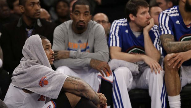 New York Knicks forward Carmelo Anthony watches the final minutes of the loss to Brooklyn from the sidelines.