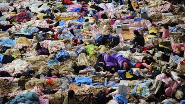 People sleep at a gymnasium used as a gathering point for relatives of the missing passengers.