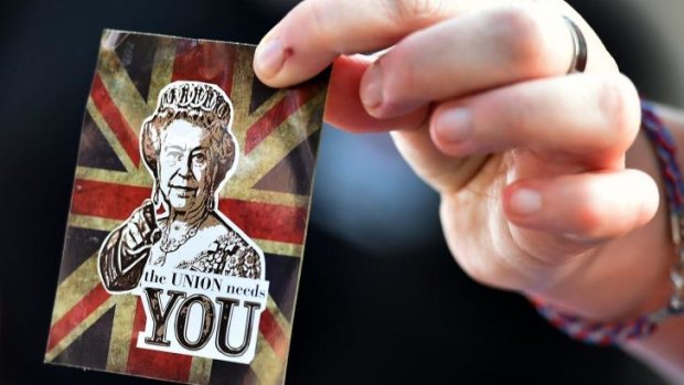 A  'no' vote supporter holds a sticker depicting an image of Queen Elizabeth II ahead of the Grand Orange Lodge of Scotland march in Edinburgh