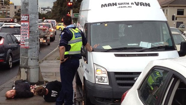 A witness said the removalists were handcuffed by police and thrown to the ground.
