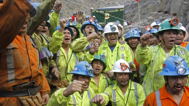 Workers who rescued miners trapped inside the Cabeza de Negro gold-and-copper mine celebrate outside the mine's entrance.