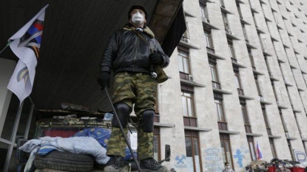 A pro-Russia protester stands at a barricade outside a regional government building in Donetsk, Ukraine.