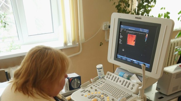 Endocronologist Olga Shalivskaya uses an ultrasound device to monitor the thyroid gland of Yana Lukach, 7, at the polyclinic in Ivankiv, Ukraine.  Ivankiv district also shows a 100-fold increase in thyroid cancer rates from 1985-2010.  