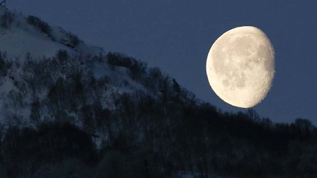 The moon is seen above the mountains in Rosa Khutor, Russia.