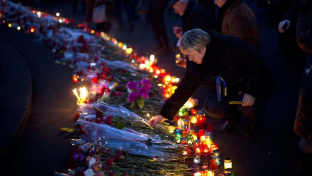 Lighting candles at a memorial for the people killed in clashes at Independence Square in Kiev.