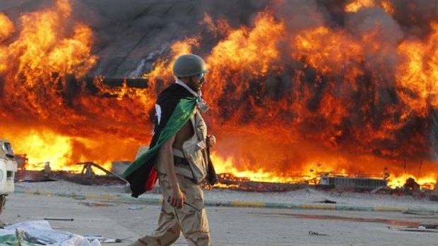 A Libyan rebel walks in the Bab Al-Aziziya compound after rebels overran Muammar Gaddafi's Tripoli bastion.