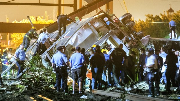 Rescue workers climb into the wreckage of the derailed Amtrak train in Philadelphia.
