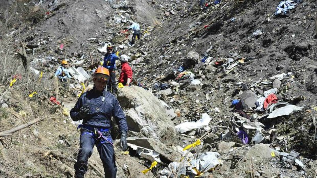 Amid the wreckage: French gendarmes and investigators make their way through plane debris at the crash site of the Airbus A320. 