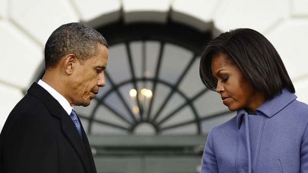 Honouring the Arizona victims ... Barack and Michelle Obama after observing a minute's silence with staff on the South Lawn of the White House on Monday.