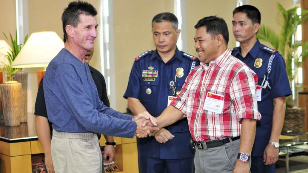 Released hostage Warren Rodwell is greeted by Philippine National Police officials and Basilan Vice-Governor Al Rashid Sakalahul on Monday.
