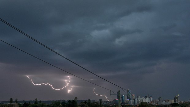 Lightning strikes over the city as the storm rolls in.