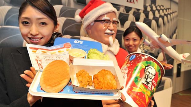 An employee of Japan Airlines shows off a plate of "AIR Kentucky Fried Chicken" at a press conference to announce their new in flight food service in Tokyo.