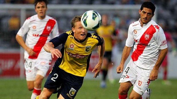 Daniel McBreen of the Mariners heads the ball in front of Simon Colosimo of the Heart.