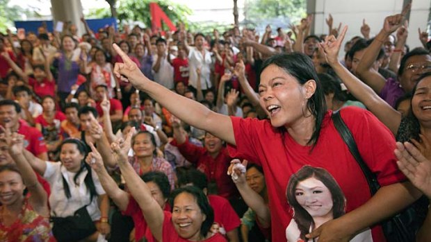 Supporters of Yingluck Shinawatra celebrate as election results come out at the Pue Thai party headquarters.