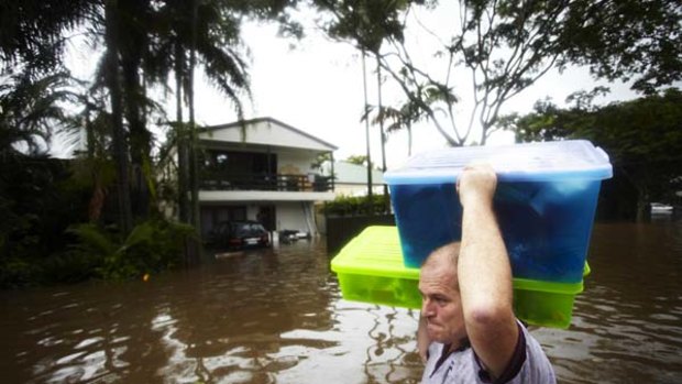 Doing what must be done ... Darren Mundie carries possessions from his flooded home in Milton, a suburb of Brisbane.