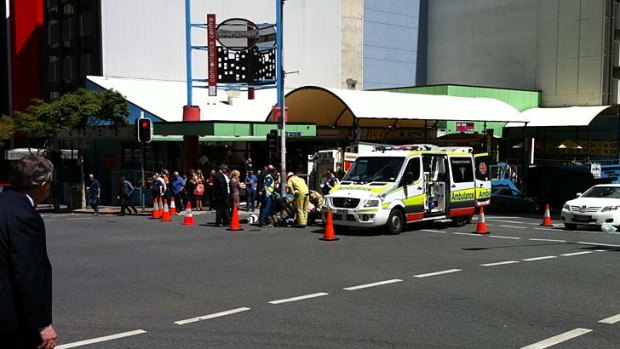 Paramedics treat a scooter rider involved in a crash in Brisbane's CBD.