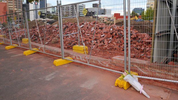 Tribute ... Flowers, left the morning after, lay at the site of the wall collapse.