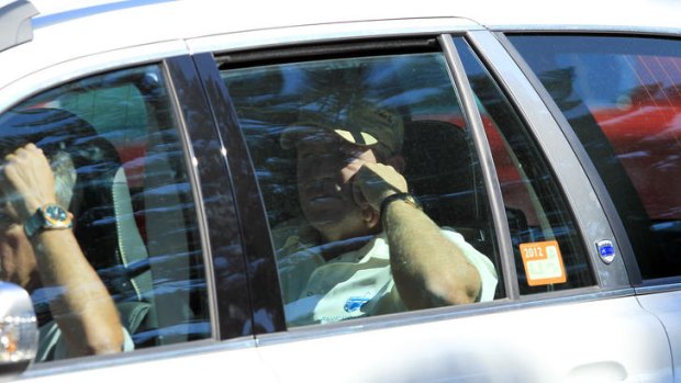 Golf rage ... John Daly leaves in a car after walking off the course at the 11th hole during day one of the Australian Open.