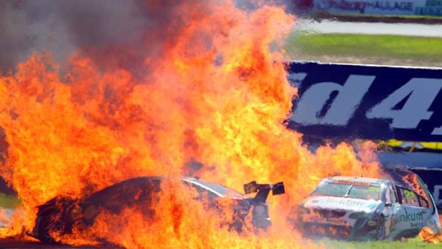 Lucky escape ... the blazing remains of the cars of Steve Owen and Karl Reindler after a major crash on the start line at Barbagallo Raceway.