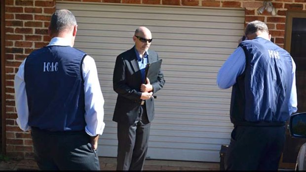 Men wearing ICAC vests outside Richard Torbay's house.