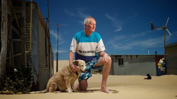 Alwyn Garland, with dog Sandy, outside his hut at Tin City, Stockton Beach.