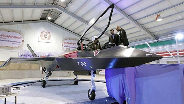 Iranian President Mahmoud Ahmadinejad, centre, and Defence Minister Ahmad Vahidi talk with the pilot of the Qaher F313.