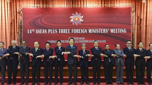 Hands across the region: Foreign ministers pose for pictures before the 14th ASEAN Plus Three Foreign Ministers Meeting.