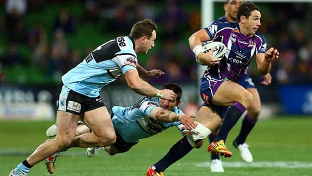 Evading the Sharks &#8230; Billy Slater evades the diving Isaac De Gois during Melbourne's last-gasp win over Cronulla that ensured the battle for the minor premiership will last another week.