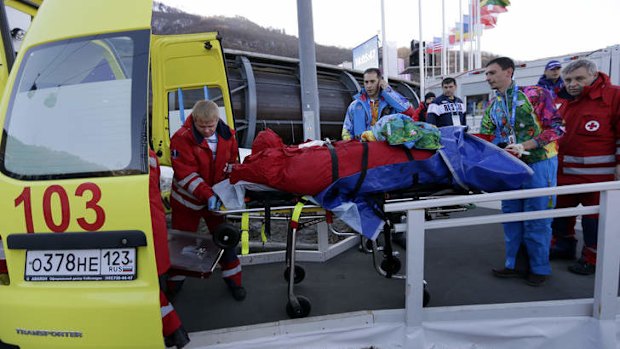 A track worker is loaded into an ambulance after he was injured when a forerunner bobsled hit him before the start of the men's two-man bobsled training on Thursday.