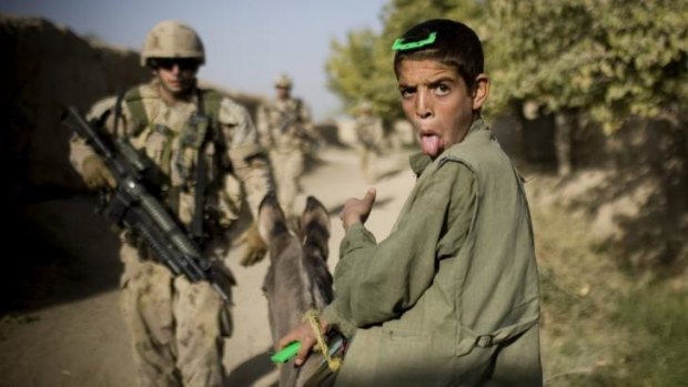 Body of work: An Afghan boy on a donkey sticks his tongue out as Canadian soldiers with the 1st RCR Battle Group patrol, in 2010.
