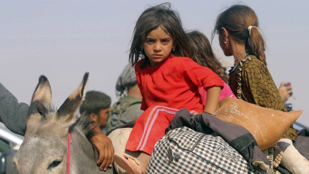 Displaced children from the minority Yazidi sect flee Islamic State militants from Sinjar, Iraq in August 2014.